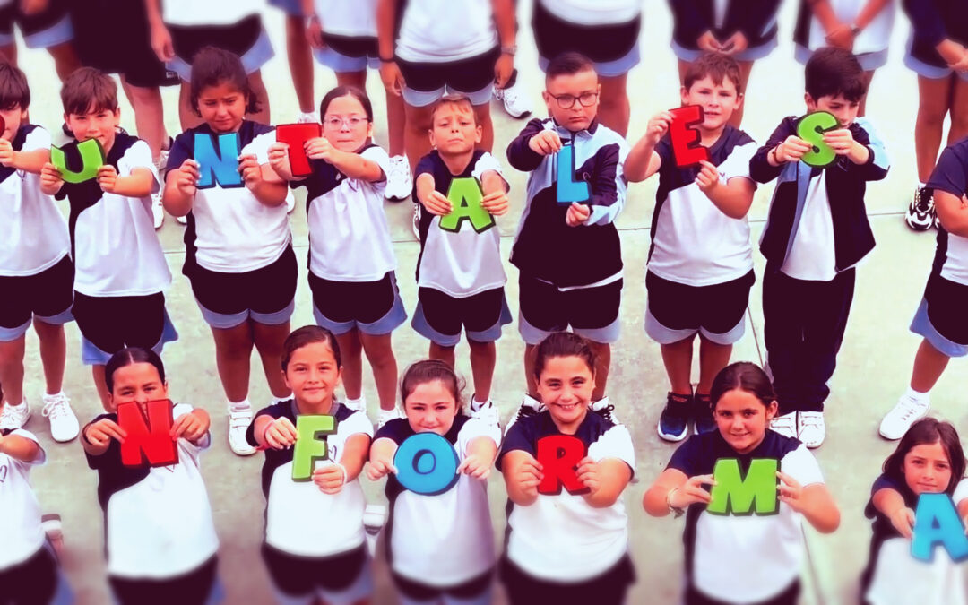 Alumnos posan en el patio del colegio y muestran las letras que forman las palabras "Puntales Informa".